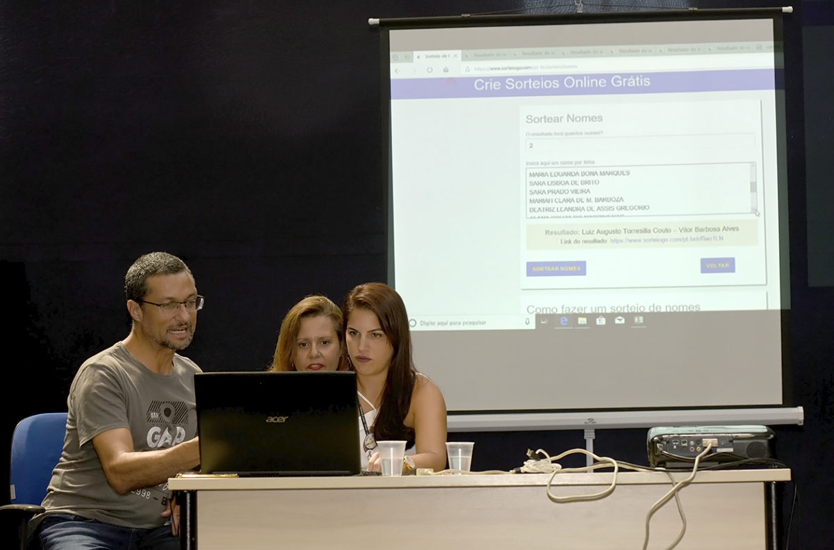 Três pessoas realizando o sorteio online, com transmissão ao vivo pelo Facebook, no palco da Sala Jundiaí do Complexo Fepasa