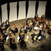 Foto de ângulo alto do palco do Teatro Polytheama durante concerto da Orquestra Municipal