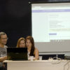 Três pessoas realizando o sorteio online, com transmissão ao vivo pelo Facebook, no palco da Sala Jundiaí do Complexo Fepasa