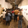 Galeria de Arte, com mostra e expectadores no corredor